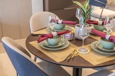a dining room table with plates and wine glasses at BLVD - Stunning Full Burj Khalifa Firework Views in Dubai