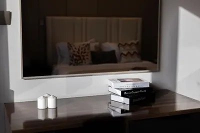 a table with books and a mirror in a room at BLVD - Stunning Full Burj Khalifa Firework Views in Dubai