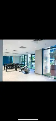 a gym with chairs and a lot of windows at Holiday homes azizi riviera in Dubai