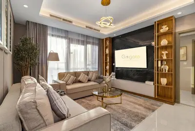 a living room with a couch and a tv at Gogoto5 1BR Burj View Infinity Pool High Floor in Dubai