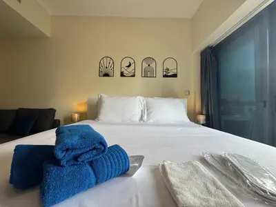 a bedroom with a bed with blue towels on it at Click Stay - JLT - Entire Studio & Balcony Lakes view Apartment -HW in Dubai