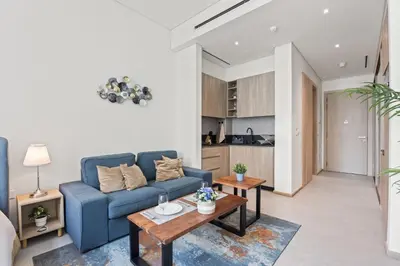 a living room with a blue couch and a table at Luxury Studio with Balcony in JVC in Dubai