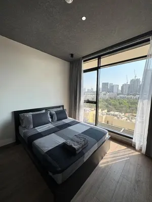 a bedroom with a large bed with a large window at Peaceful Modern Home Overlooking JVC Green Park in Dubai