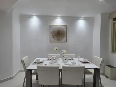 a white dining room with a white table and chairs at Luxury Furnished 2 BR with Stunning Sea View in Dubai
