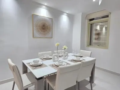 a white dining room with a white table and chairs at Luxury Furnished 2 BR with Stunning Sea View in Dubai
