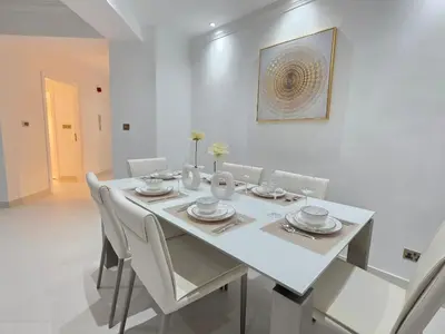 a white dining room with a white table and chairs at Luxury Furnished 2 BR with Stunning Sea View in Dubai