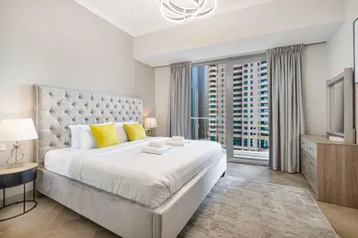 a bedroom with a large bed and a large window at StayMada - Ocean Heights Marina City and Sea Views in Dubai