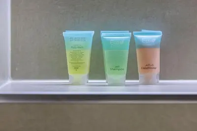 a row of four bottles of moisturizers on a shelf at StayMada - Ocean Heights Marina City and Sea Views in Dubai