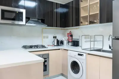 a kitchen with a washer and dryer in it at Gemz by Danube, Private Pool, Al Furjan - Onelink in Dubai