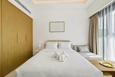 a bedroom with a large white bed with towels on it at Estudio Pearl en Dubai by beBalmy in Dubai