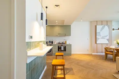 a kitchen with a counter and two stools at Designer's Selection - Luxury in the Heart of DIFC in Dubai