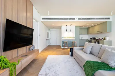 a living room with a large television and a couch at Designer's Selection - Luxury in the Heart of DIFC in Dubai
