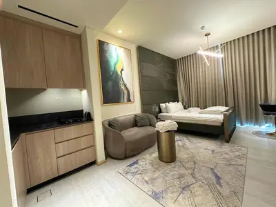 a hotel room with a bed and a couch at Luxury Studio with Balcony, Pool, Coworking in JVC in Dubai