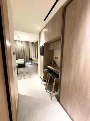 a hotel room with a table and a room at Luxury Studio with Balcony, Pool, Coworking in JVC in Dubai