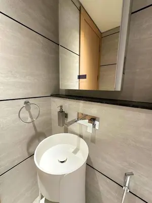 a bathroom with a white toilet and a mirror at Luxury Studio with Balcony, Pool, Coworking in JVC in Dubai