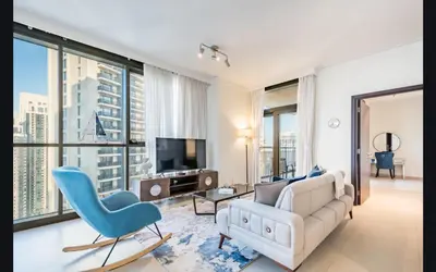 a living room with a white couch and blue chairs at Luxury 1025 sq feet 1 bed apartment in 29 floor Dubai Creek Residences in Dubai