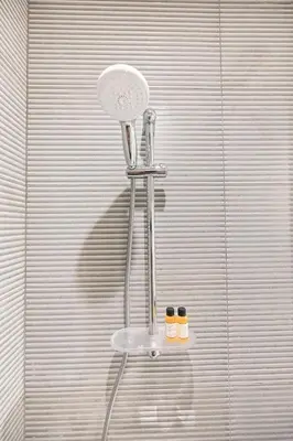 a shower seat with two bottles on a wall at Golden Stays - Cozy 1BR Retreat I Skyline Views & Urban Charm in Dubai