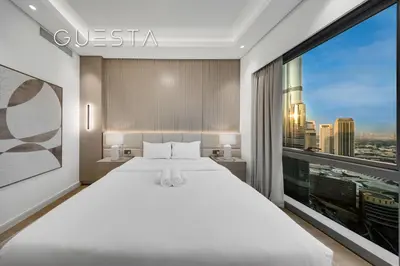 a bedroom with a large bed and a large window at Grande Tower by Emaar - Burj Khalifa and Fountain Views, Downtown Dubai in Dubai
