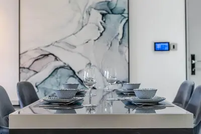 a table with wine glasses and plates on it at TRPS - MAG 318, Business Bay - Spacious 1BR plus Maids, Furnished, City View in Dubai