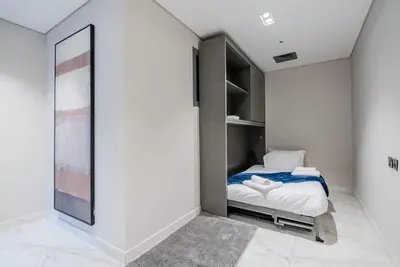 a small bedroom with a bed and a mirror at TRPS - MAG 318, Business Bay - Spacious 1BR plus Maids, Furnished, City View in Dubai