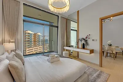 a bedroom with a large white bed and a large window at Lux 1 Bedroom Apartment in Majan in Dubai