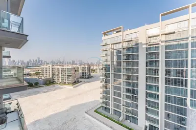 an apartment building with a view of the city at Glimpse of Burj Khalifa 2BR, 15-Minute Drive to Burj Khalifa and Downtown Landmarks, District One Phase III Residences 13, Mohammed Bin Rashid Al Maktoum City by Deluxe Holiday Homes in Dubai