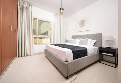 a bedroom with a large bed and a window at Stunning 1 Bed in Al Dhafra 2 The Greens in Dubai