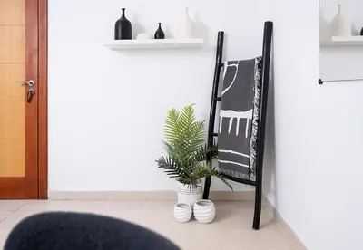 a black chair sitting next to a plant in a room at Stunning 1 Bed in Al Dhafra 2 The Greens in Dubai