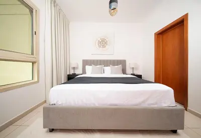 a bedroom with a large bed and a window at Stunning 1 Bed in Al Dhafra 2 The Greens in Dubai