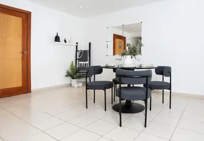 a dining room with a black table and chairs at Stunning 1 Bed in Al Dhafra 2 The Greens in Dubai
