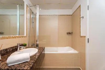 a bathroom with a sink and a bath tub at GuestReady | 2BR | Stunning Canal View, JBR in Dubai