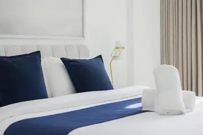 a bedroom with a bed with blue and white pillows at Luxury Marina Views Near Mall & Beach, with Gym, Swimming Pool & Car Park in Dubai