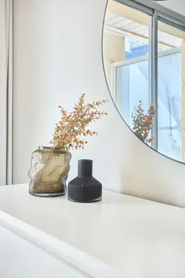 a bathroom with a mirror and a vase on a shelf at Frank Porter - Westside Marina in Dubai