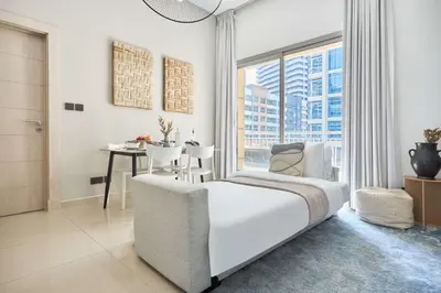 a bedroom with a bed and a table and a window at Frank Porter - Westside Marina in Dubai