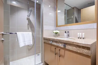 a bathroom with a glass shower and a sink at Frank Porter - Burj Vista Tower 2 in Dubai
