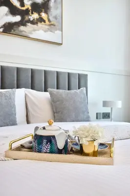 a tray with a tea set on a bed at Frank Porter - Marina Diamond 4 in Dubai