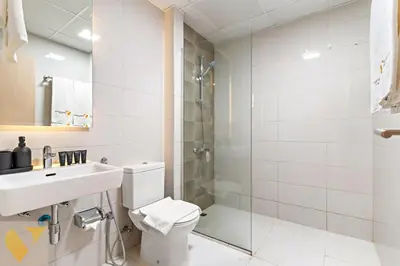 a bathroom with a toilet and a sink and a shower at Vogue JVC Jeewar Tower Near Circle Mall, One Bedroom Apartment with Balcony and City View, Access to all Amenities in Dubai