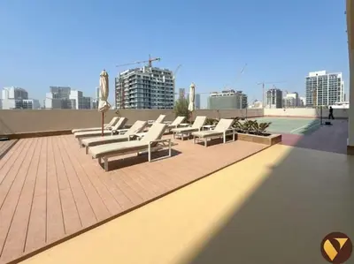a row of lounge chairs on the roof of a building at Vogue JVC Jeewar Tower Near Circle Mall, One Bedroom Apartment with Balcony and City View, Access to all Amenities in Dubai