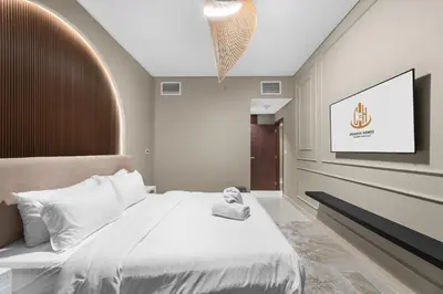 a bedroom with a white bed and a tv at Exclusive 2BR I Panoramic Views I Downtown Dubai in Dubai