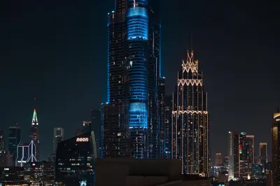 a lit up city skyline at night with at Exclusive 2BR I Panoramic Views I Downtown Dubai in Dubai