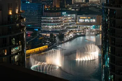 a large water fountain in the middle of a city at night at Exclusive 2BR I Panoramic Views I Downtown Dubai in Dubai