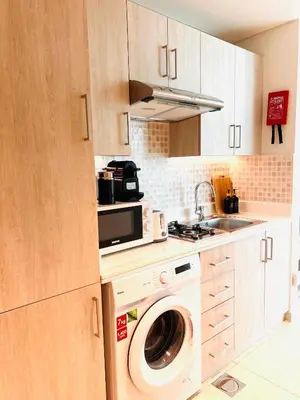a kitchen with a washing machine and a microwave at Séjour raffiné et inoubliable in Dubai