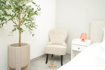 a bedroom with a chair and a plant at Evasion Moderne a Business Bay vue sur le canal in Dubai
