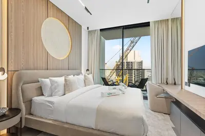 a bedroom with a large bed and a large window at Minimalist Studio in Binghatti Azure in Dubai