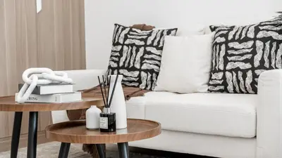 a living room with a white couch and two tables at Azizi Riviera 5, Meydan Close to Downtown - Onelink in Dubai