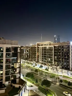 a view of a city at night with buildings at Azizi Riviera Studio High Floor Partial Burj View in Dubai
