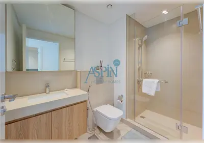 a bathroom with a shower and a toilet and a sink at Downtown Views II - Burjkhalifa fireworks in Dubai