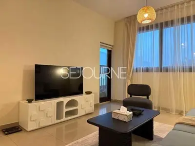 a living room with a flat screen tv on a wall at Cozy & Bright 1BR La Riviera Estate A in Dubai