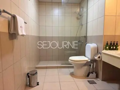 a bathroom with a shower with a toilet and a sink at Cozy & Bright 1BR La Riviera Estate A in Dubai