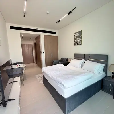 a bedroom with a bed and a desk and a television at A place like home for relaxation in Dubai